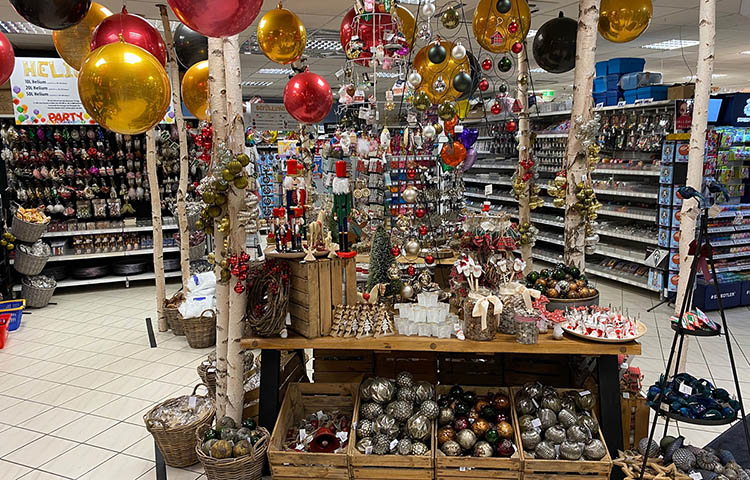 Weihnachtlich dekorierter Bereich mit Kugeln, Kerzen, Figuren und Dekoartikeln
